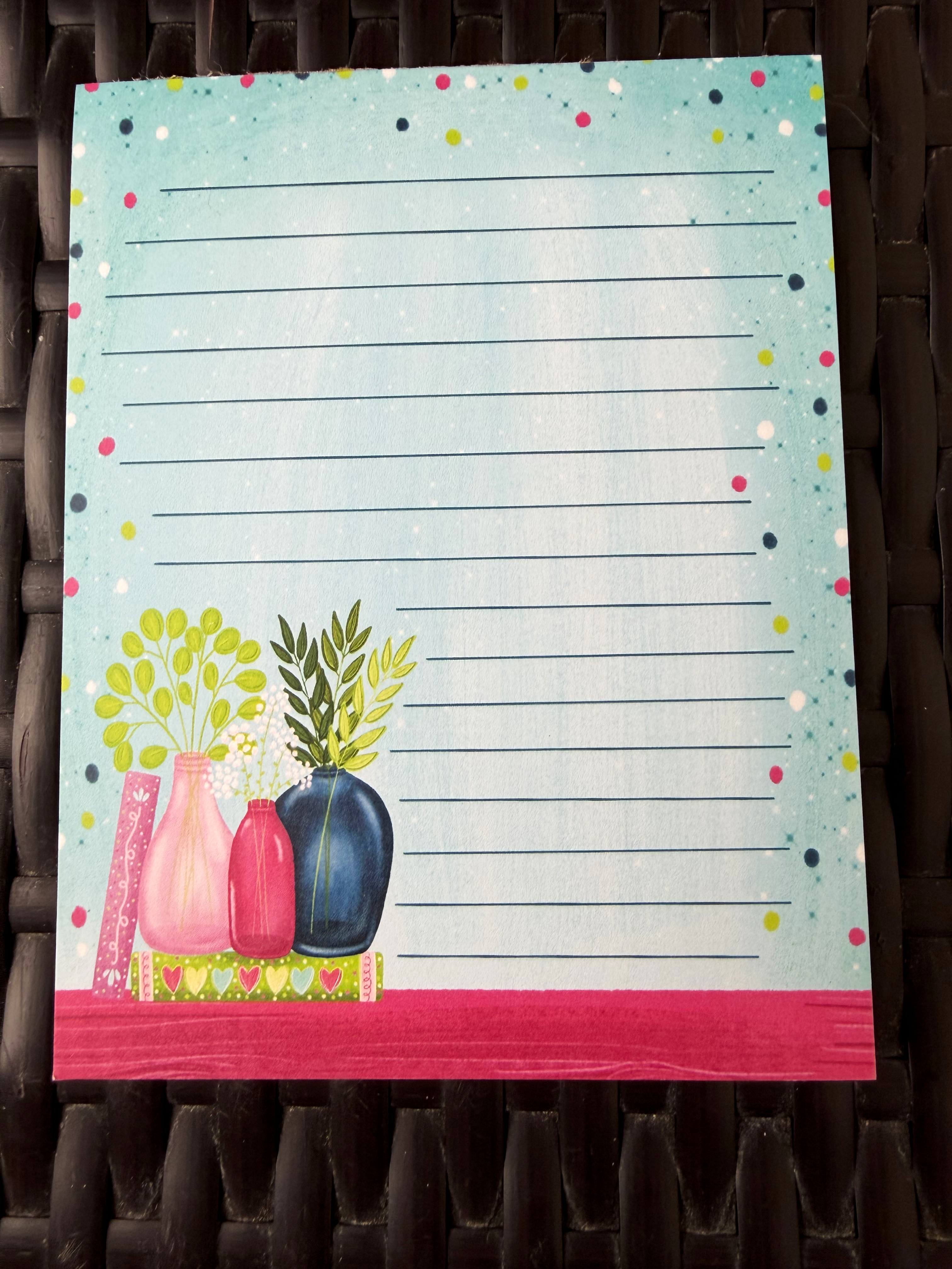 Notepad with decorative design of vases and plants on a polka dot background