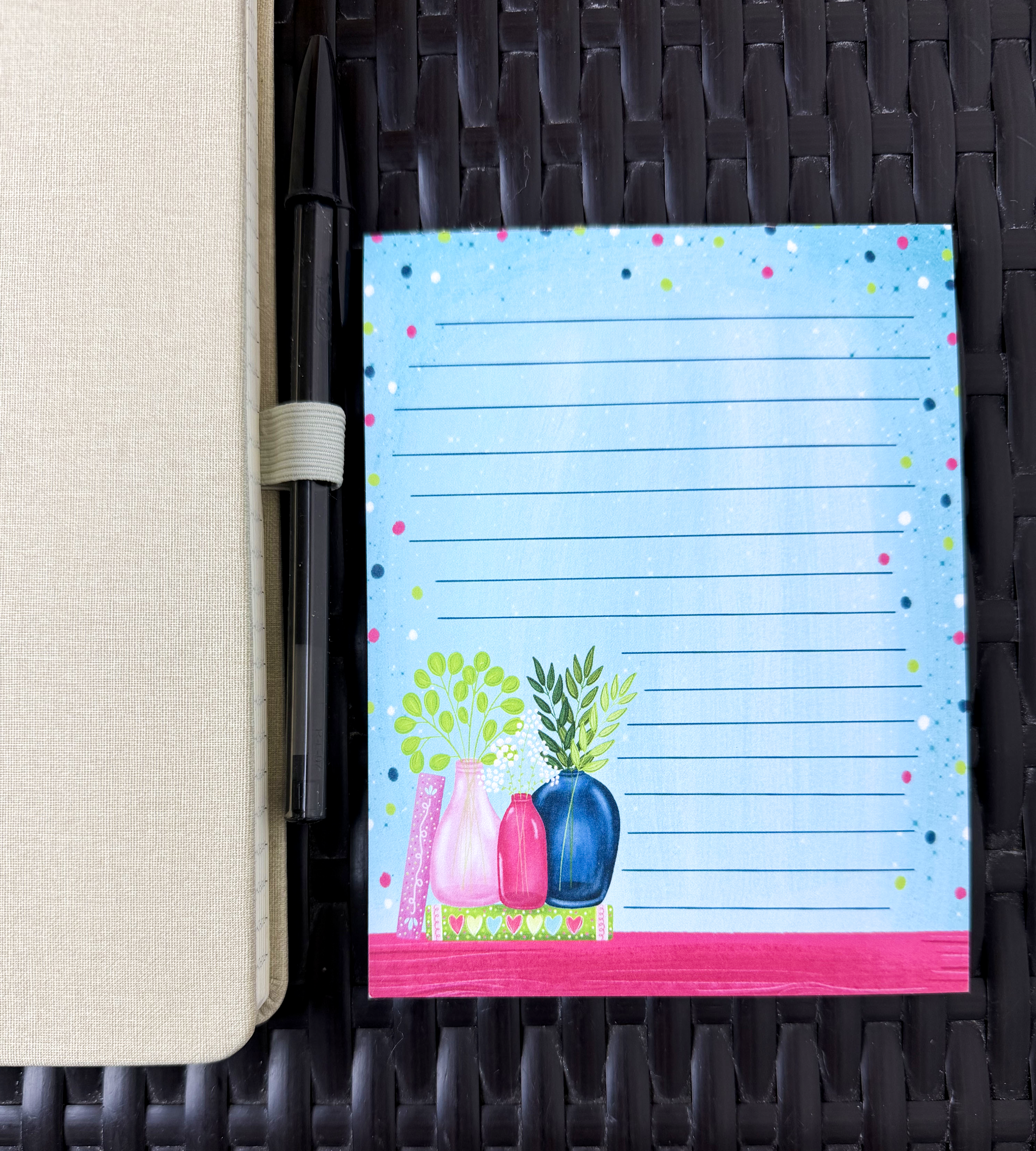 Notepad with decorative cover featuring plants on a textured surface