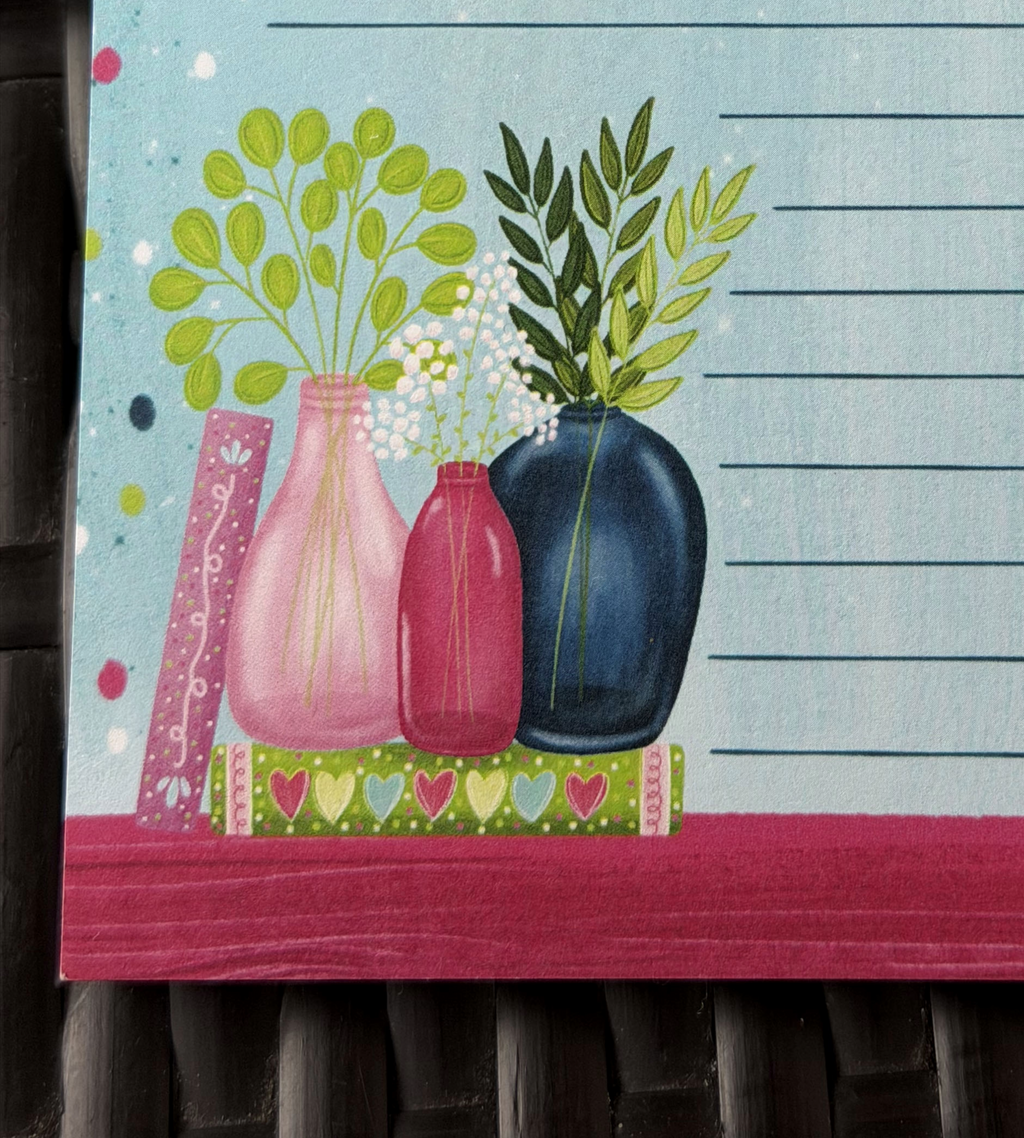 Decorative towel with colorful vases and plants on a wooden surface