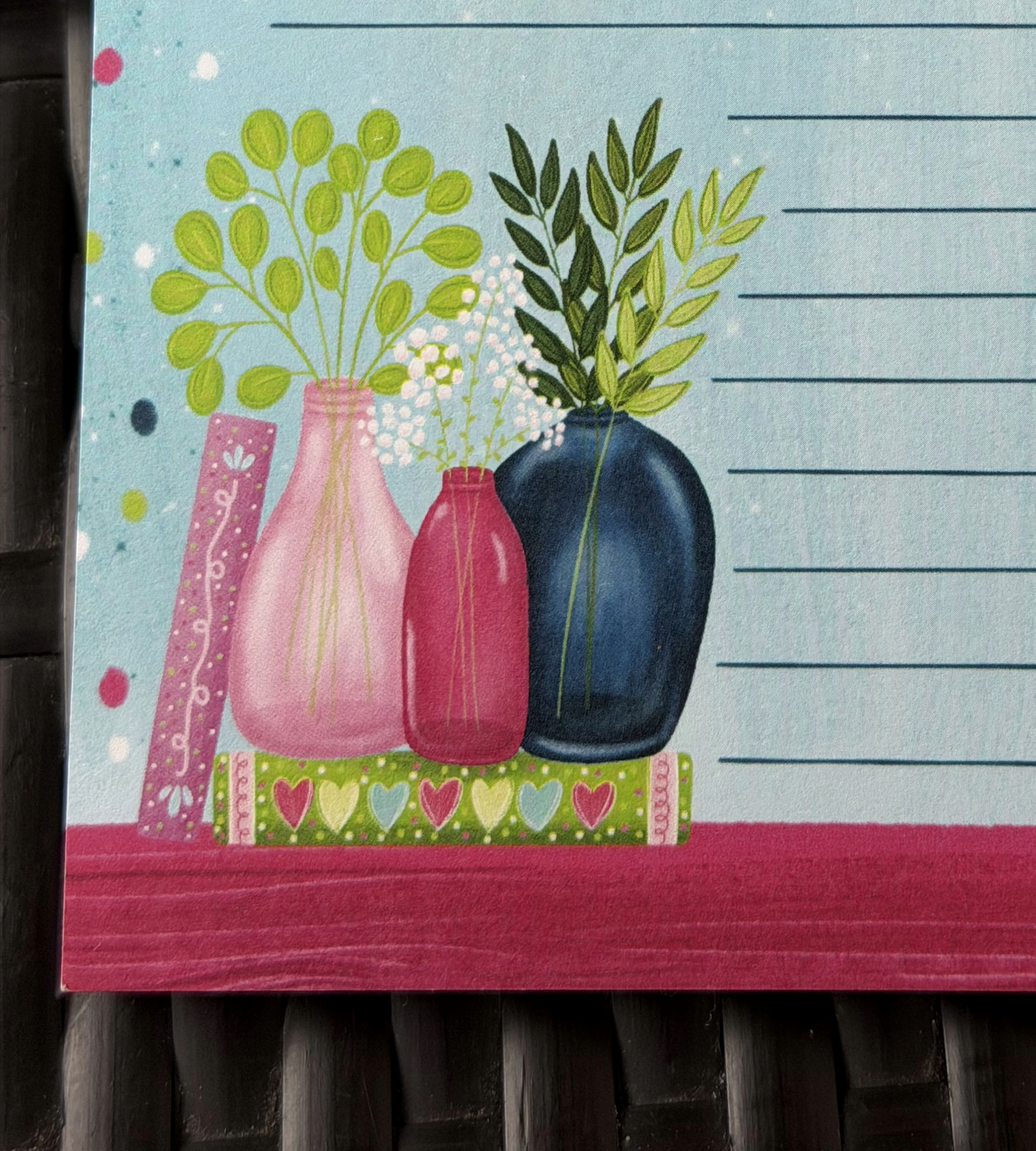Decorative towel with colorful vases and plants on a wooden surface