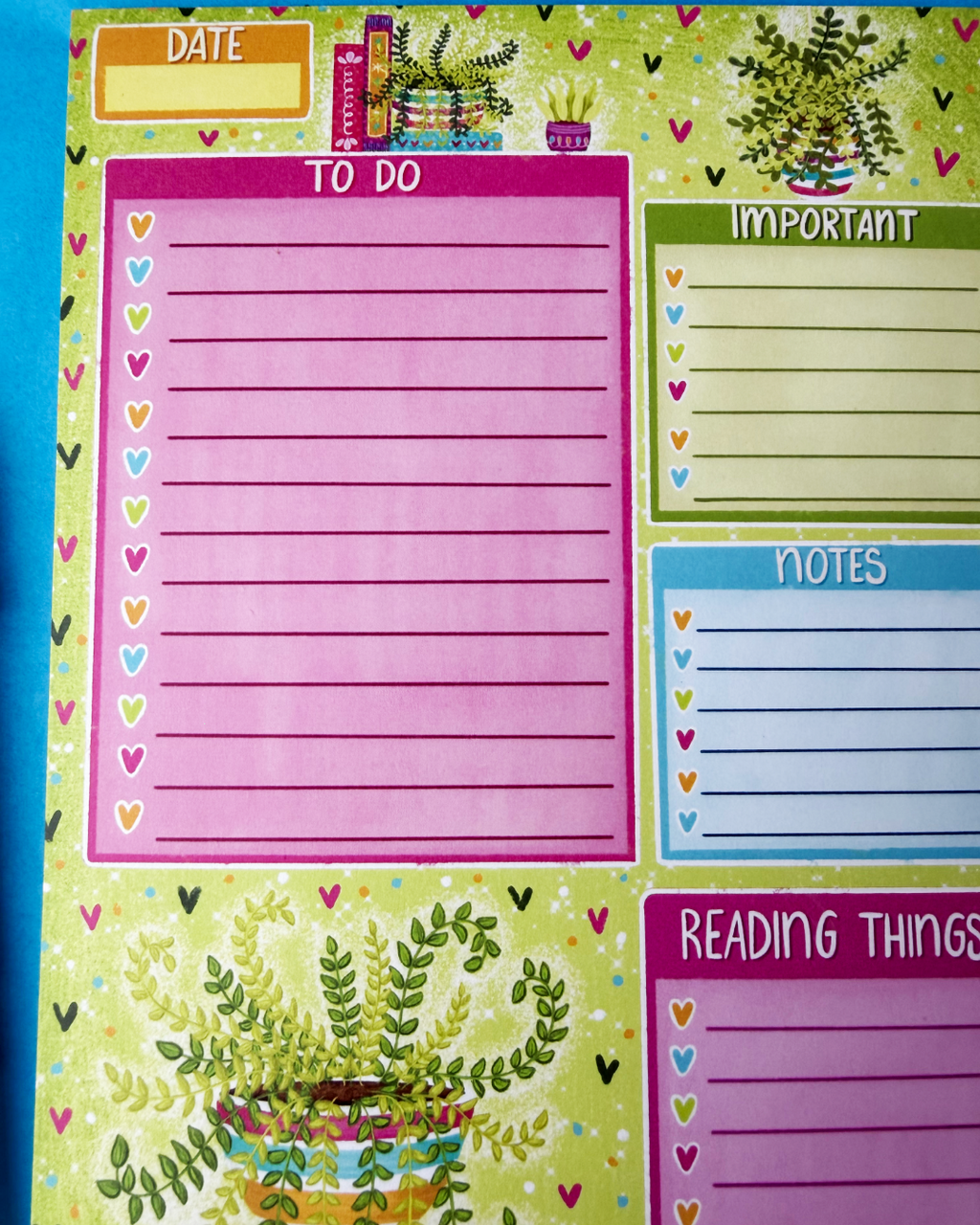 Colorful planner pad with various sections for notes and reminders on a green background.