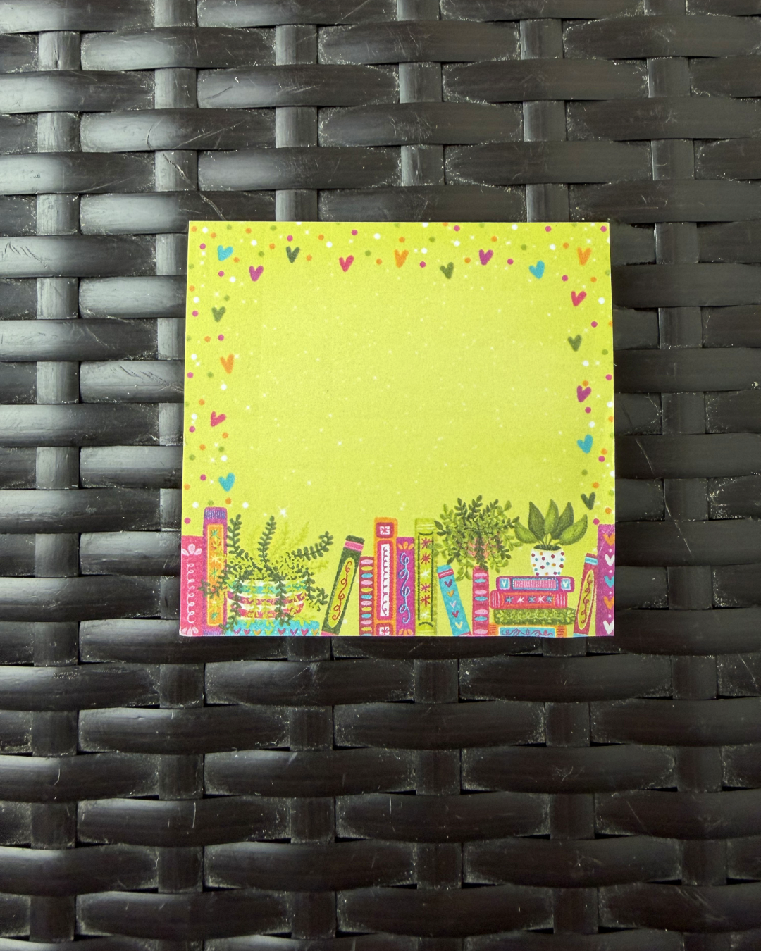 Colorful book-themed notepad on a woven black surface